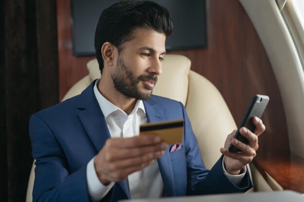 A businessman from Mexico paying on a card with his mobile.