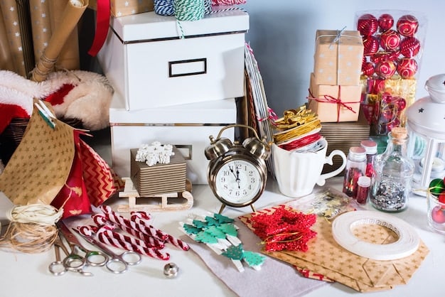 A collection of recycled materials organized on a table, ready to be transformed into Christmas decorations. This includes plastic bottles cut into shapes, colorful scraps of fabric, buttons, cardboard rolls, and old newspapers. A pair of scissors and glue are also visible, indicating the tools needed for the craft.