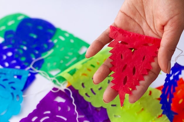 A person filling a partially decorated piñata with colorful candies and small toys. The piñata is open at the top, ready to be sealed.