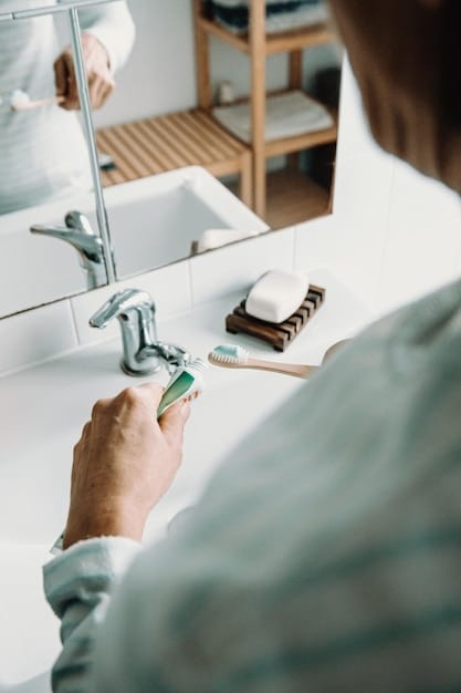A person's hands cleaning a silver ring with a toothbrush and toothpaste over a white sink. The focus is on the ring and the detailing of the cleaning process.