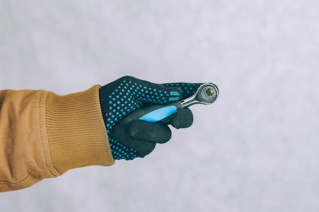 A detailed shot of a person's hands wearing protective gloves, scrubbing a rusty wrench with a toothbrush dipped in a mixture of vinegar and salt. The focus is on the scrubbing motion and the rust particles being removed.